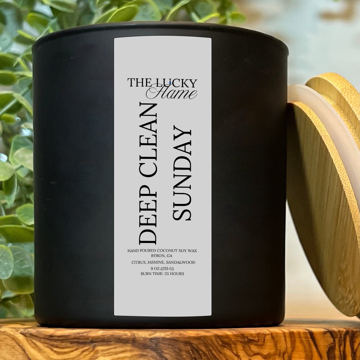 Deep Clean Sunday candle in a sleek 9 oz black jar with notes of cotton, citrus, and soft musk, styled with white towels and minimalist clean decor.